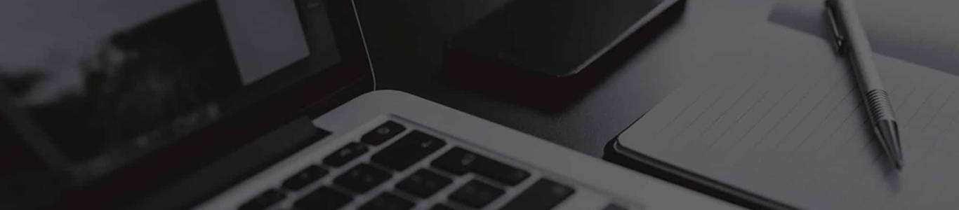 Desk setup with laptop, pen, and notepad for productivity